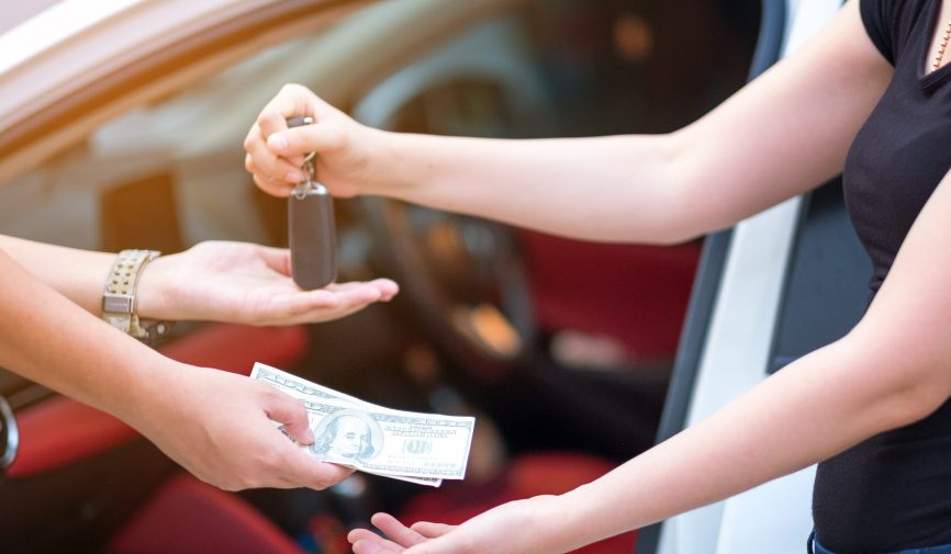 woman in showroom giving dollars money and taking keys from car woman in showroom giving dollars money and taking keys from car