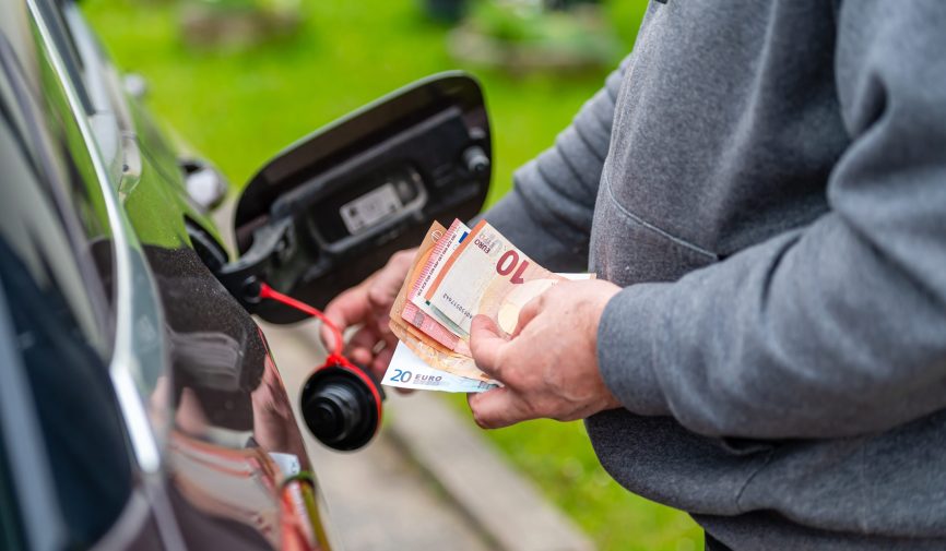a man counts money standing at an open fuel tank, the concept of a man counts money standing at an open fuel tank, the concept of