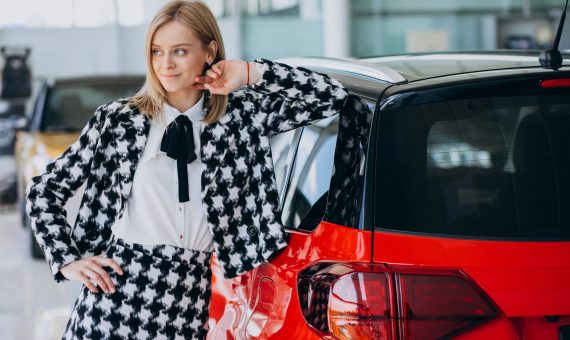 Young woman buying a car in a car showroom
