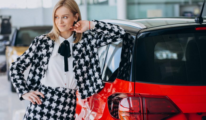 Young woman buying a car in a car showroom